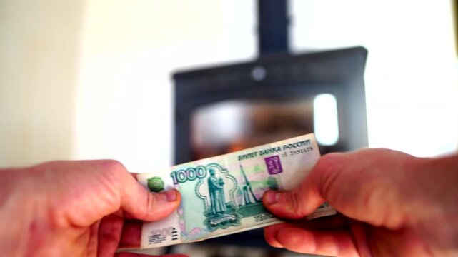 Heating payment. Save money wood stove. Russian ruble banknotes for payment of heating firewood. Budget wood heat home. Russian bill money pay for heating costs in heating season. Heat house in Russia