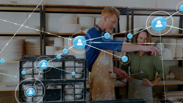 Studio team pointing at clipboard starting blue net growing from node across racks mapping stock