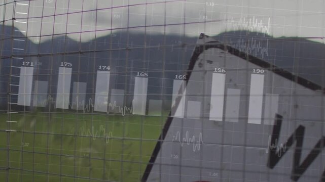 Vertical video: Tilted road sign through wire fence overlay fading in bars rising showing tech data