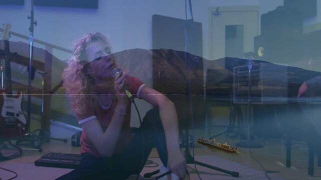 Guitarist strumming cueing singer rehearsing, singing with mic in studio, mountain-boat overlay