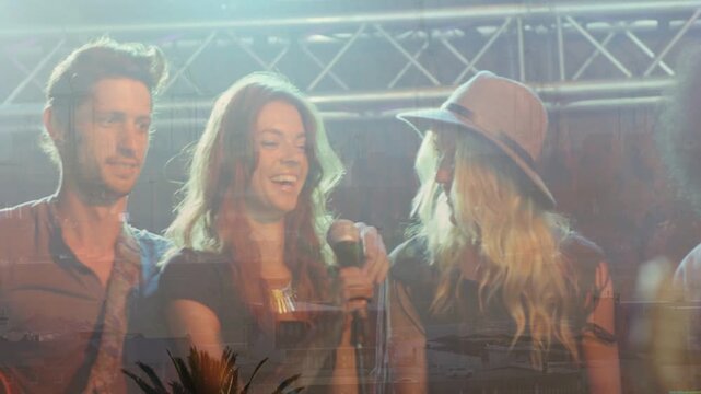 Band raising tambourine cueing singer adjusting mic for music start under lights over performers