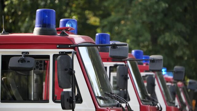 Fire engines lined up in a row, flashing blue lights indicating emergency readiness
