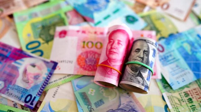 Chinese yuan, US dollars among various currencies background. Banknotes different countries denominations. Chinese yuan, US dollars and foreign currencies. World's reserve currency in global trade.
