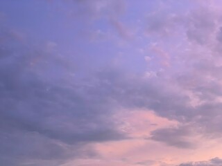 Obraz premium Soft pastel sky with layered clouds at sunset, low upward angle, gentle focus and smooth gradient light. Calm, dreamy mood. Ideal for backgrounds, nature, wellness, travel, and atmospheric design them