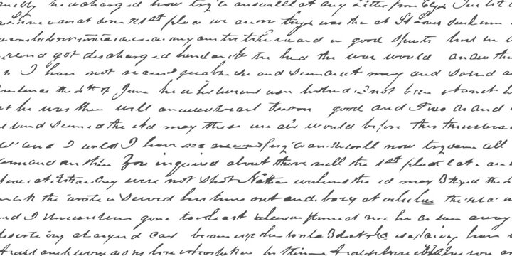 A detailed close up view of an old handwritten letter featuring cursive script on aged paper surface.
