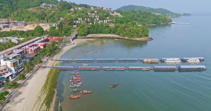 Aerial shot of tropical beach cleanup activity with a tractor removing green algae from the shoreline at Patong Beach. The image emphasizes environmental care, tourism impact, and coastal restoration