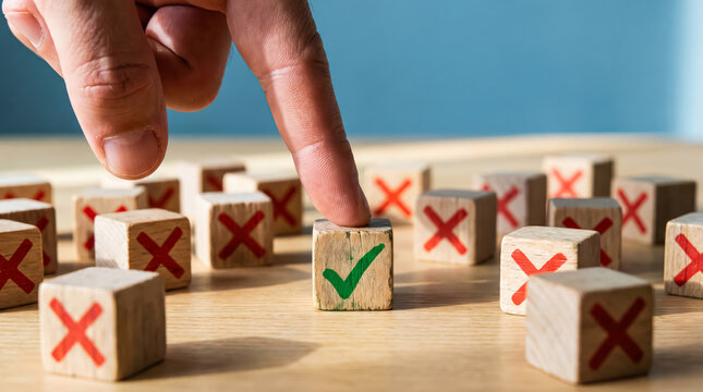 Hand selecting a wooden block with a green check mark among many blocks with red crosses