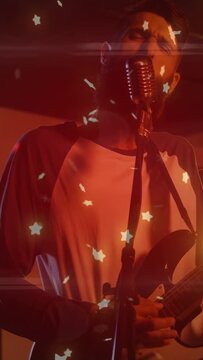 Vertical video: Lead singer playing guitar, singing at gig, camera closing in, stars rising to peak