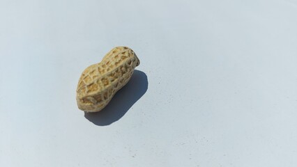 Naklejka premium image of roasted peanuts in shells with a dry and crunchy texture, isolated on a clean white background. 