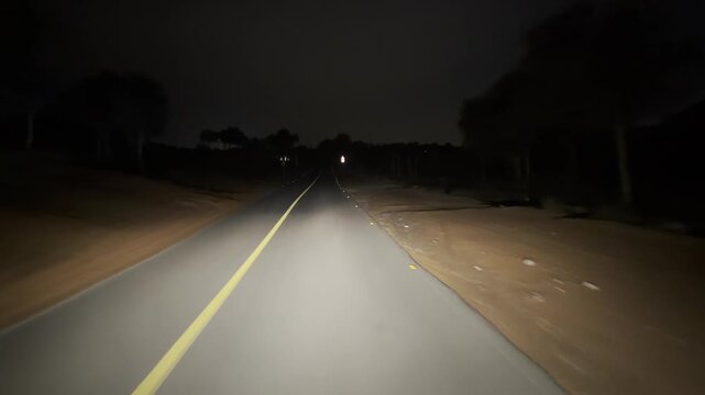Stunning night road cutting through the quiet desert at The Ritz‑Carlton Al Wadi.