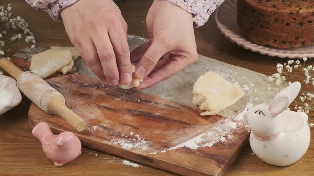 A woman rolls marzipan balls on a board to decorate a cupcake, cake, or make marzipan candies. Step-by-step video recipes. Horizontal video.