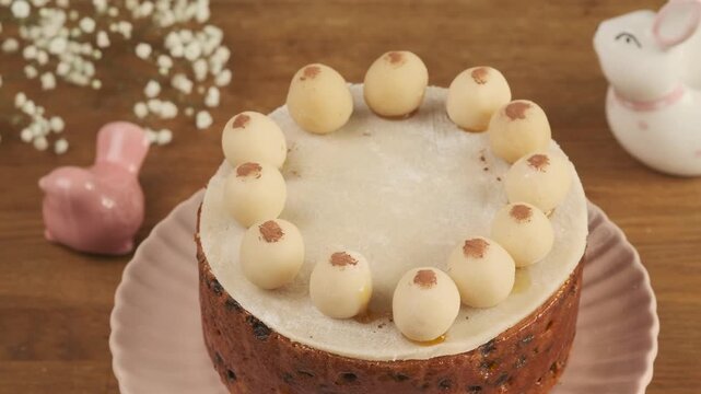 British Easter Simnel cake decorated with marzipan balls on a wooden table. Step-by-step video recipes. Horizontal video. Happy Easter
