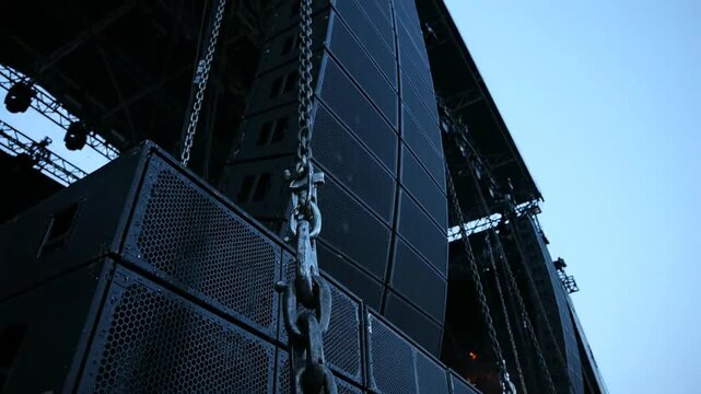 Professional Line Array Speakers and Subwoofers with Rigging Chains on Outdoor Stage