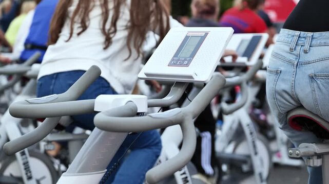 People training on exercise bikes during an outdoor group spinning class