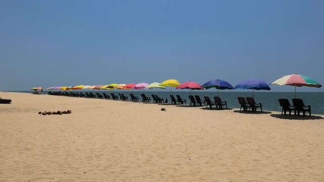 The beach with colorful umbrellas and chairs installed for tourists | Marari Beach, Alappuzha, Kerala, India