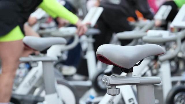 Indoor cycling class with people exercising on stationary bikes for fitness