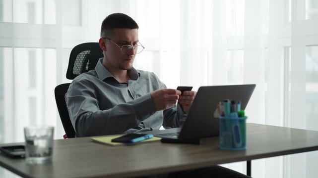 Businessman using a credit card and laptop for online payment in the office.
Online money transfer to a bank account.
Entering a card PIN to log in to your bank account.