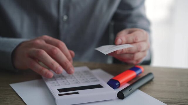 Man checking receipts and calculating budgets with a calculator.
Paper bill payment receipts, online bank payment methods