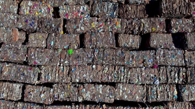 Drone aerial view of large paper rolls inside a paper manufacturing facility. The scene highlights industrial production, storage, logistics, and factory layout from an overhead perspective.
