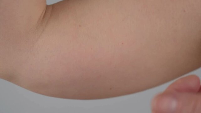 person touching fat weak biceps and feel bad about himself close up view.