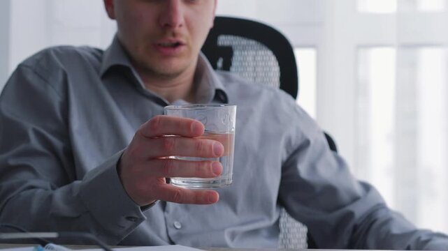 A person drinks water with trembling hands and experiences tremors.
Symptoms of Parkinson's disease.