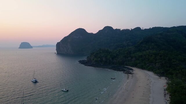 Koh Muk, Thailand: Aerial drone of the Farang or Charlie beach in the famous Koh Muk in the Andaman sea in Trang province in southern Thailand during a cinematic sunset with cliff and sandy beach