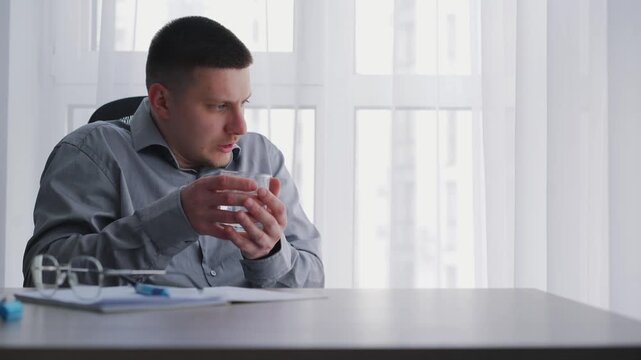 A person drinks water with trembling hands and experiences tremors.
Symptoms of Parkinson's disease.