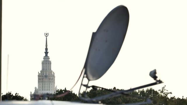 Satellite dish receiving signals with Moscow State University building in background