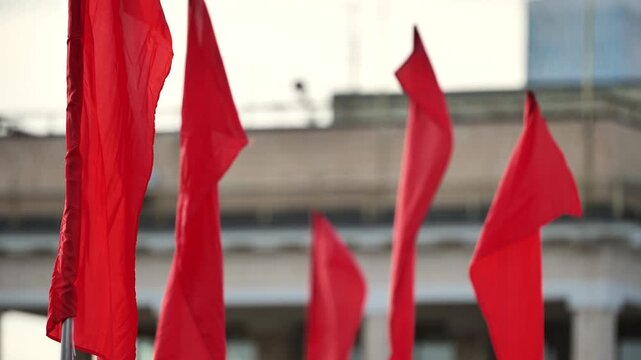 Red flags waving in wind representing protest, revolution, and ideology
