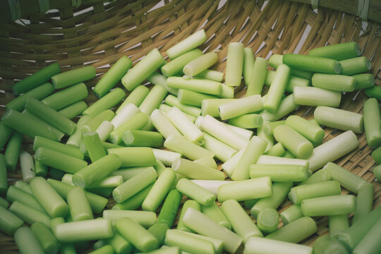 Rustic macro of fresh chopped garlic scapes in a traditional woven bamboo basket