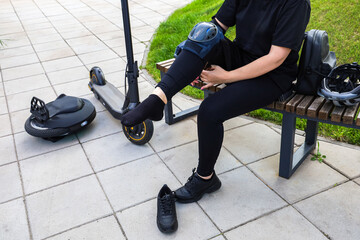 Woman adjusting knee pad after riding electric scooter and unicycle © ir1ska
