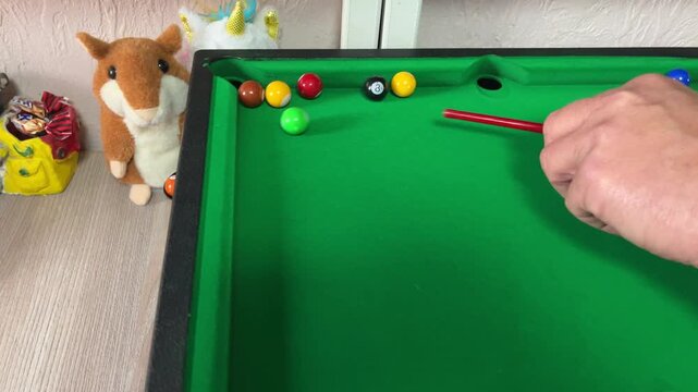 Mini billiard table with colorful balls and cue, hobby and entertainment concept, leisure activity, tabletop game, playful scene, indoor fun, copy space