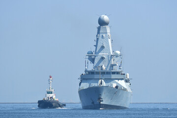 HMS Dauntless Type 45 destroyer of the Royal Navy sailing on Tokyo Bay with tugboat, Japan © zapper