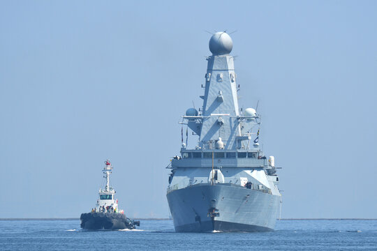 HMS Dauntless Type 45 destroyer of the Royal Navy sailing on Tokyo Bay with tugboat, Japan