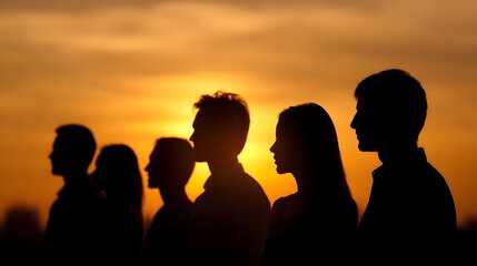 Fototapeta premium A group of people stands together in silhouette against a vibrant glowing sunset sky symbolizing and a bright future