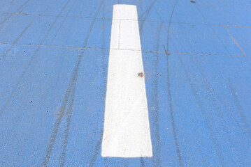 Fototapeta premium Close-up of a smooth blue track with a bold white center line