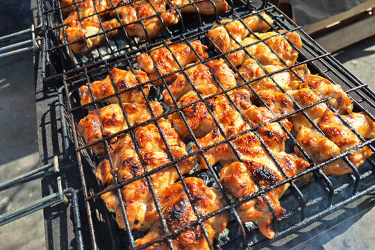 Grilled chicken pieces on barbecue