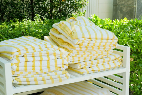 Yellow folded striped beach towel at swimming pool,sea beach, gym fitness in resort hotel,concept of summer accessories.