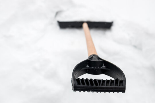 Snow shovel ready for work in freshly fallen snow