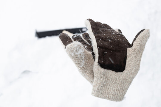 knitted white gloves on the handle of a shovel left after work