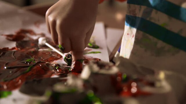 young child is playing with paint