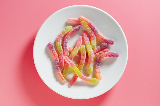 Sour gummy worms on plate.