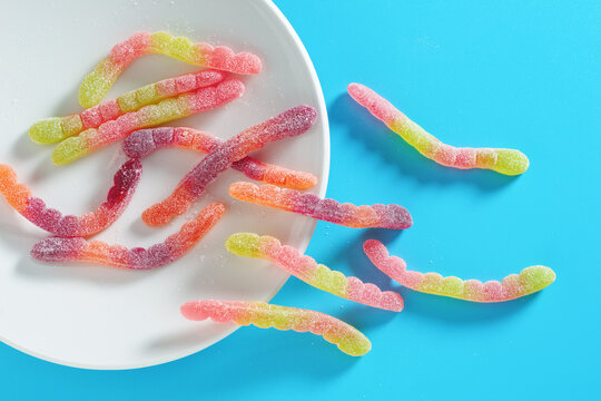Sour gummy worms on plate.