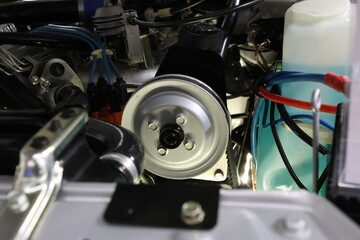 Fototapeta premium Detailed close-up of a clean car engine bay featuring a silver pulley and spark plug wires