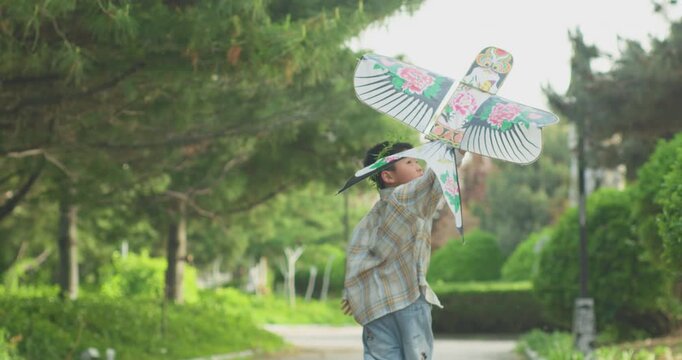 A Chinese mother and child play outdoors wearing willow leaf-woven clothes.
