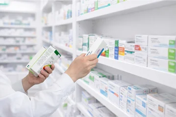 Fotobehang Apotheek Pharmacist selecting medicine box from shelf in pharmacy, healthcare and retail drugstore concept  © Stanisic Vladimir