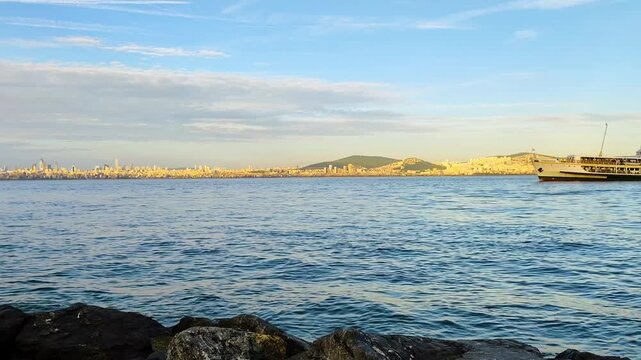 Traditional Turkish Passenger Ferry Navigating Through the Marmara Sea with Istanbul City Skyline and Buildings in the Background, Captured from Kinaliada Island Shore