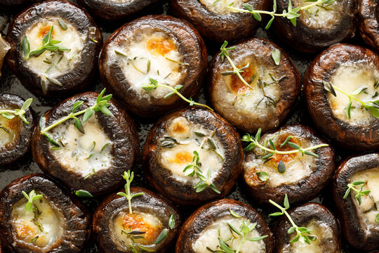 Brown mushrooms stuffed with mozzarella cheese and seasoned with thyme, top view