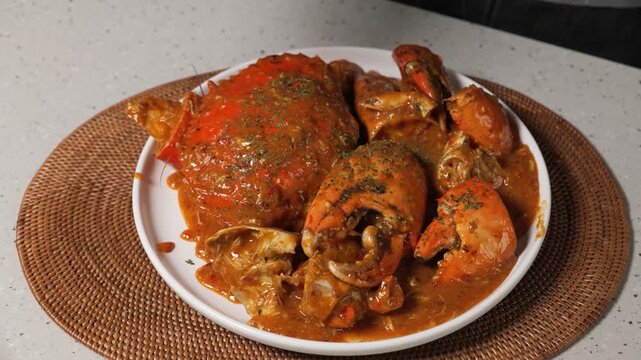 Gourmet chilli mud crab seafood boil served on a white plate