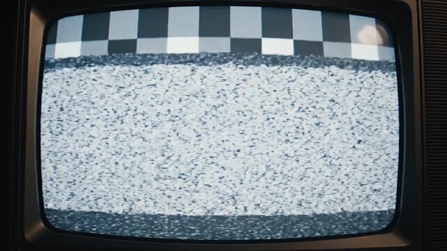 A vintage television screen displaying static noise and a test pattern signal